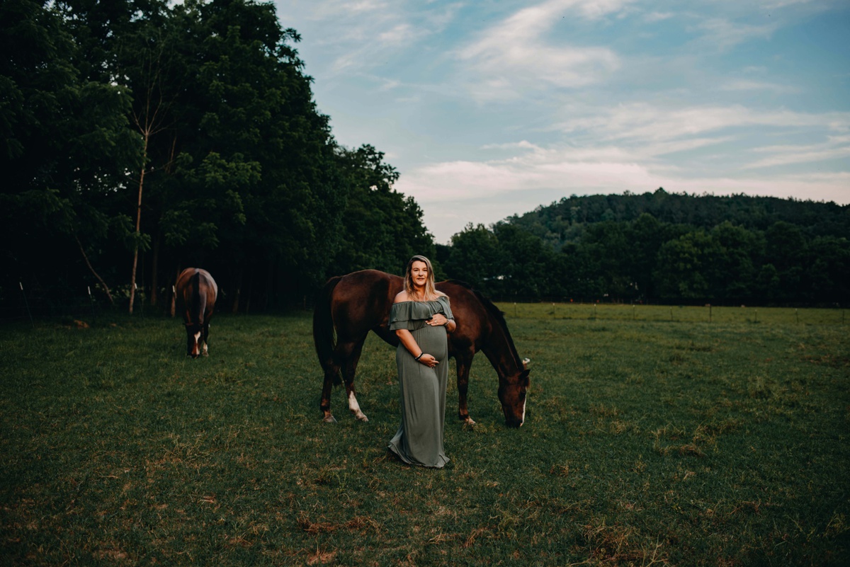 Pregnant mother standing with horses at Foxberry Farms in Dallas, GA.