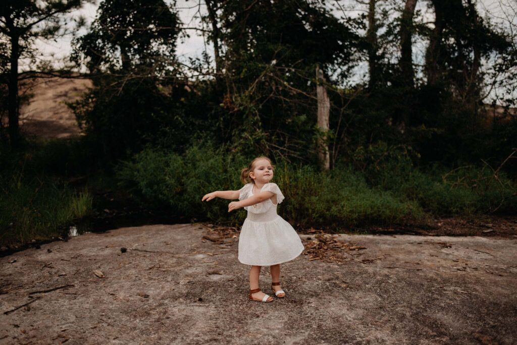 Little girl twirling in a dress on top of a mountain near Atlanta, GA.