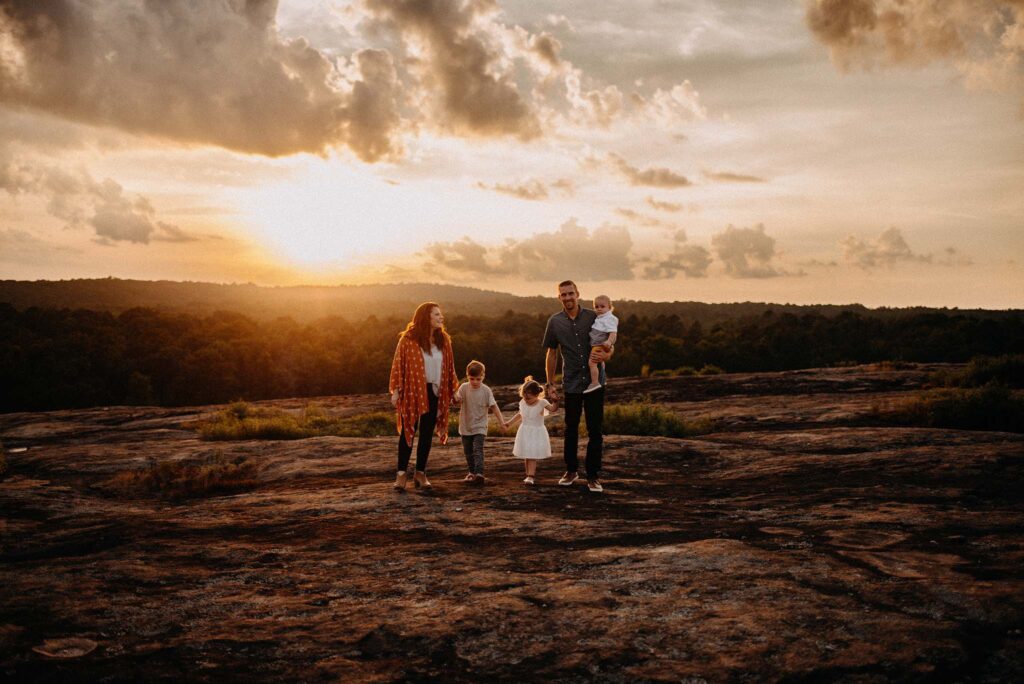 Family walking in the sunset during their family photo session photographed by a Mareitta family photographer.
