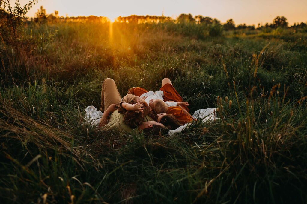 Family laying in the sunset at Nash Farms Battlefield during family photos photographed by a GA photographer.
