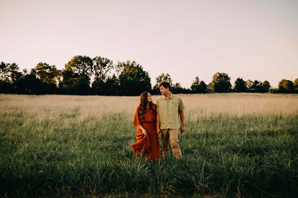 Parents walking in the field at Nash Farms Battlefield in the sunset photographed by a GA photographer.