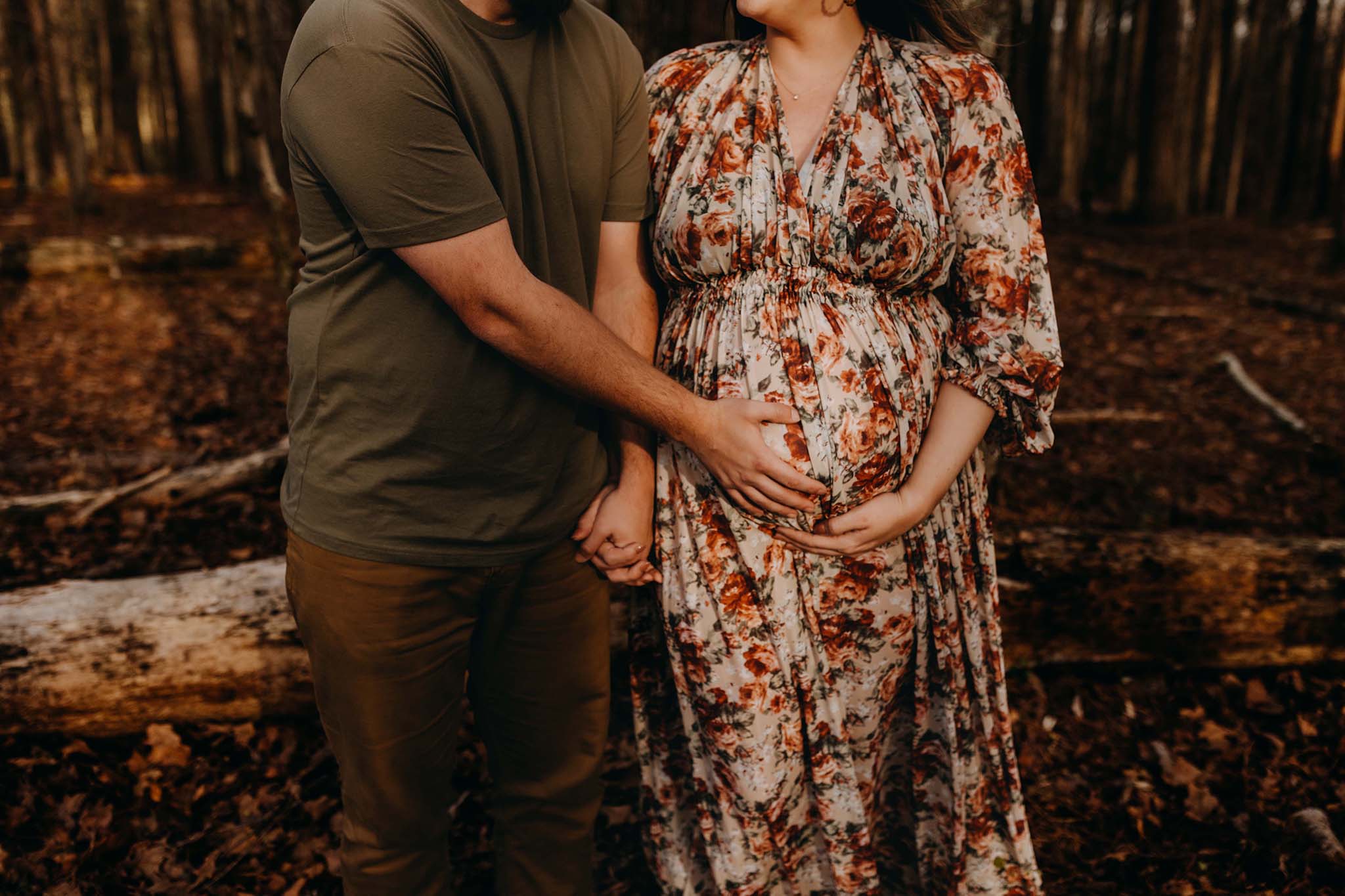 Mom and dad holding their baby belly bump for maternity photos.